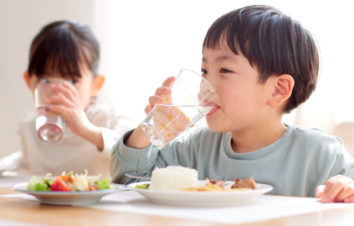 子どもたちが健康的な食事と水分補給をしている風景
